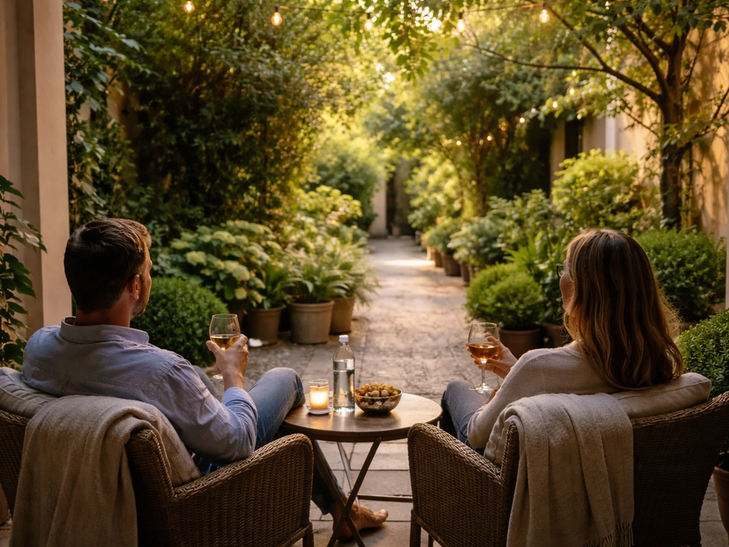 Guests relaxing on a quiet patio with greenery, looking outward in peaceful courtyard light.