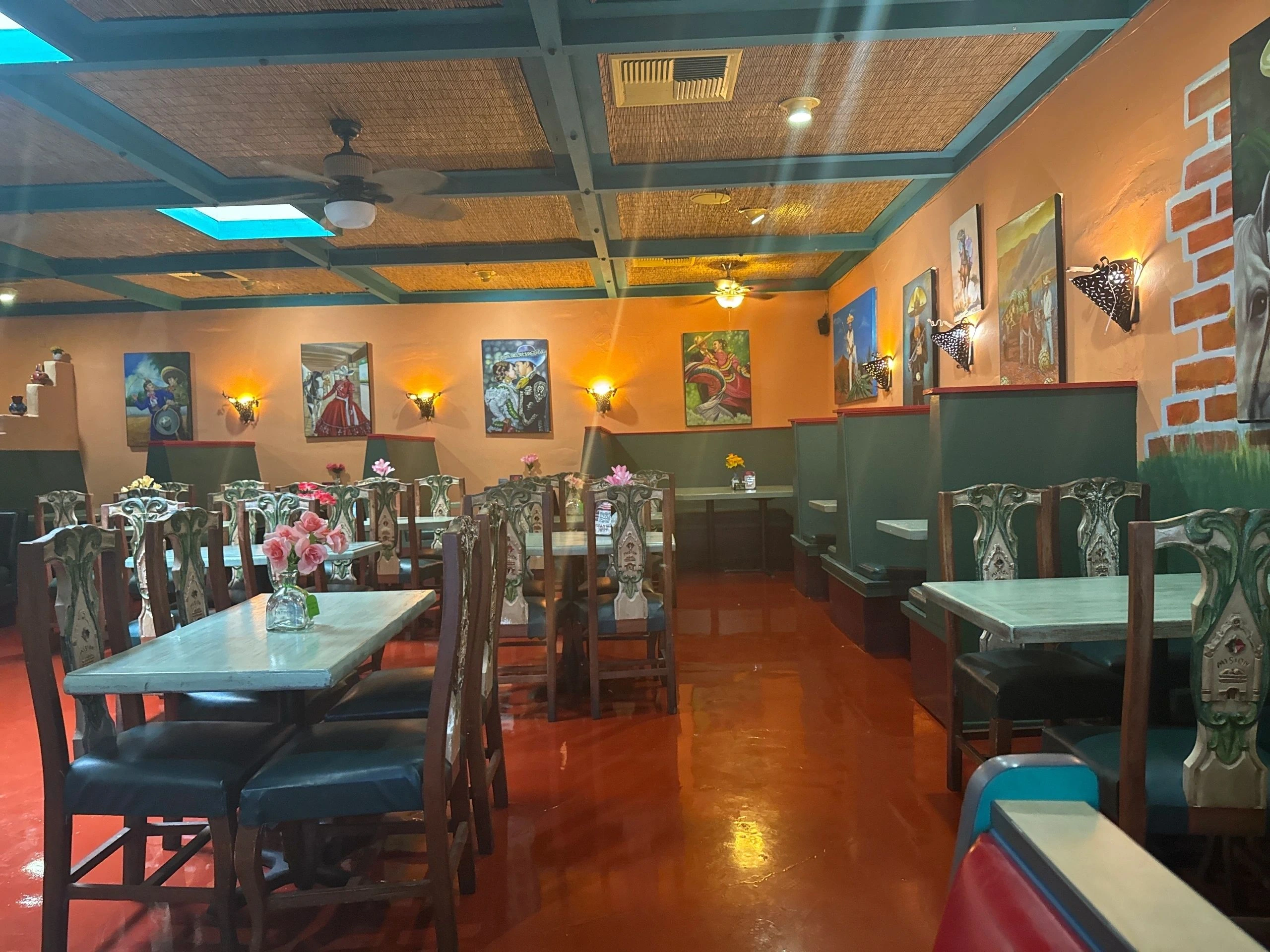 Interior dining room at East Patio Mexicano with colorful wall art, booths, tables, and warm lighting