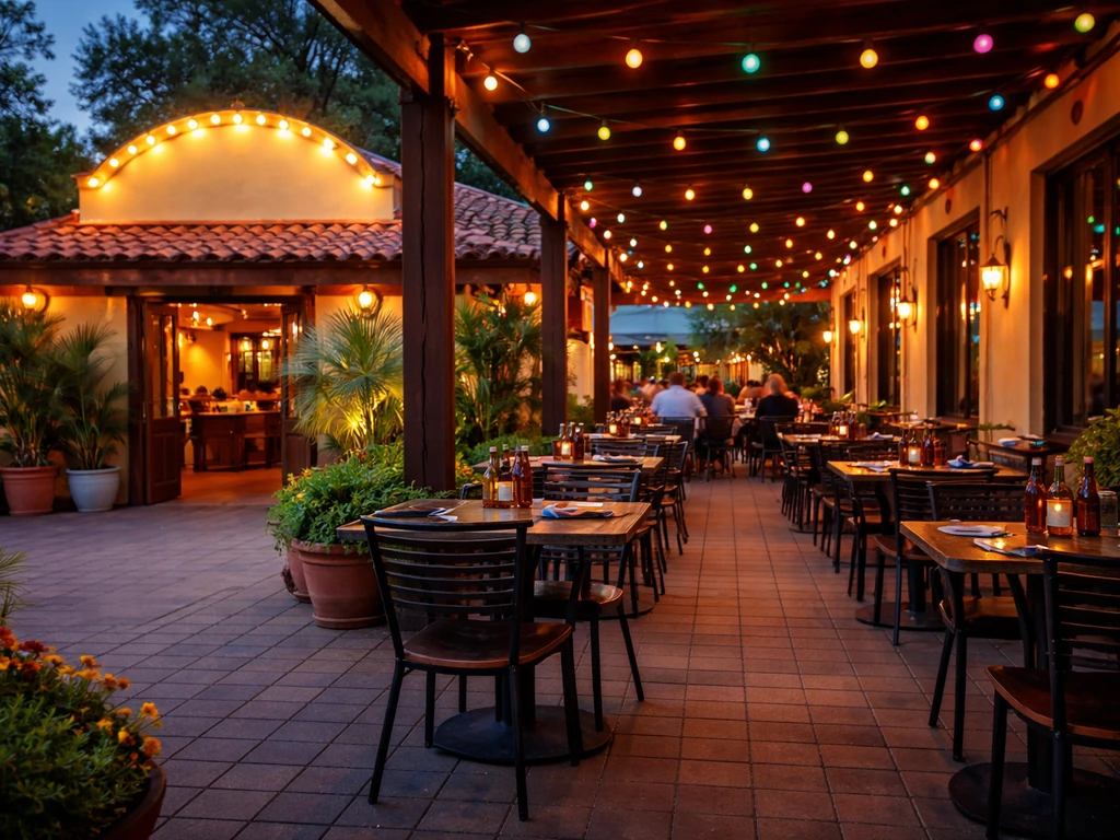 Warm evening view of a Mexican restaurant patio with colorful lights, tables, and relaxed diners.